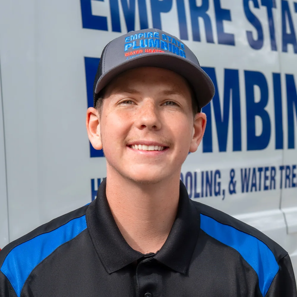 Empire State Plumbing technician by a company van at the Nassau, NY shop