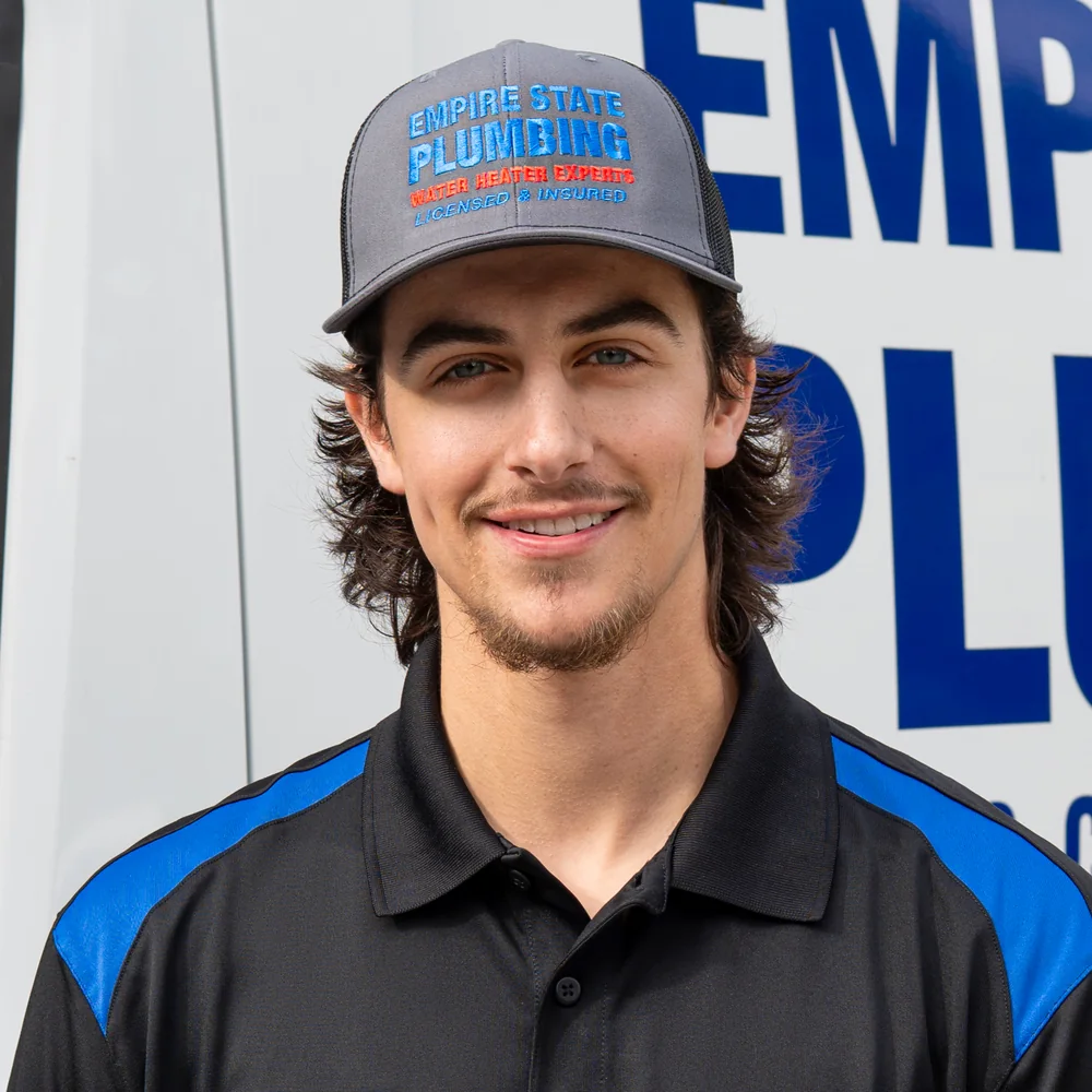 Empire State Plumbing plumbing and HVAC technician beside a service van