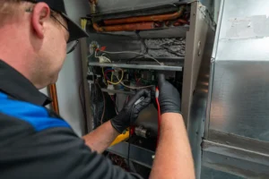 Empire State Plumbing technician using a multimeter to diagnose a furnace control board