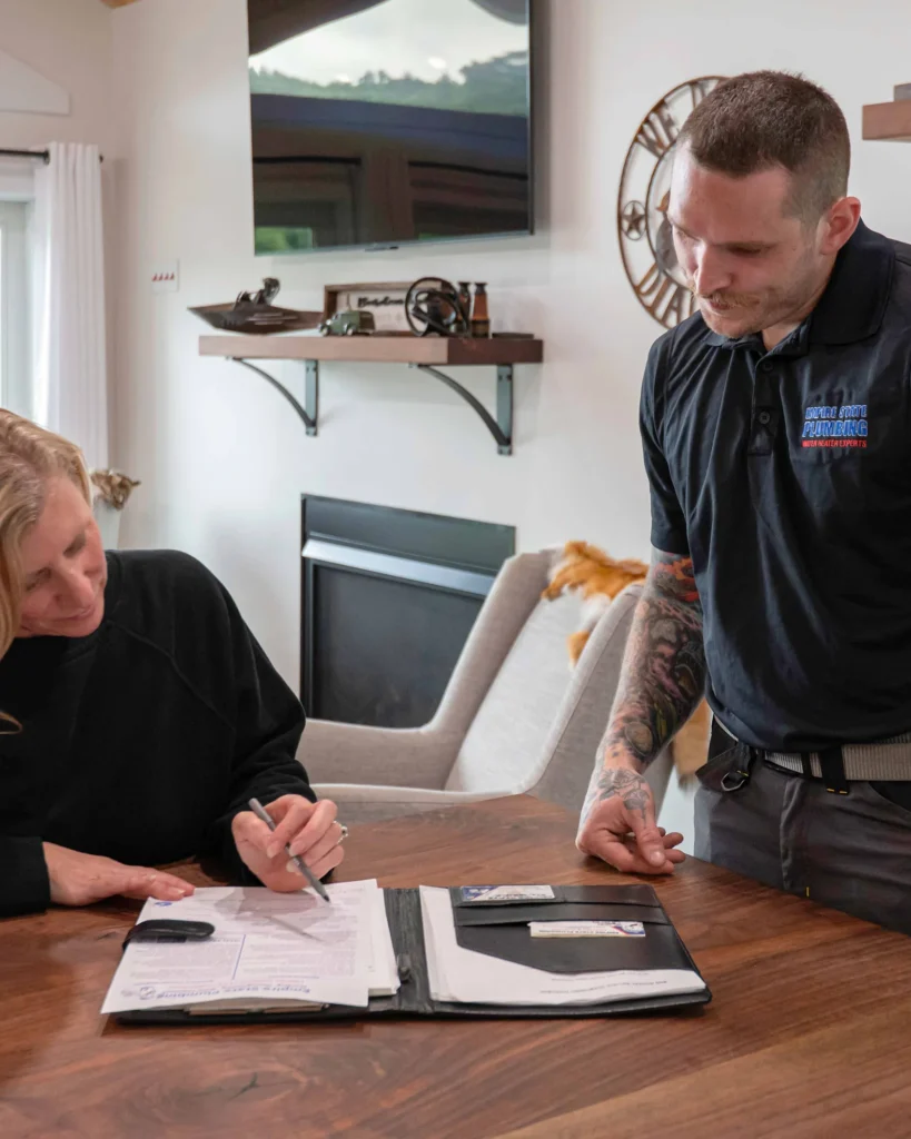 An Empire State Plumbing technician reviewing flexible payment plan options with a homeowner at their kitchen table