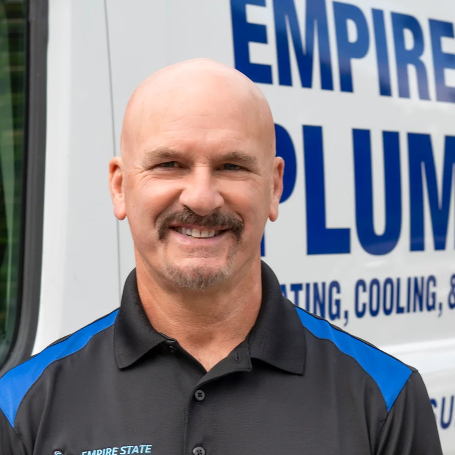 Tom Darling, owner of Empire State Plumbing, standing by a company service van in Nassau, NY